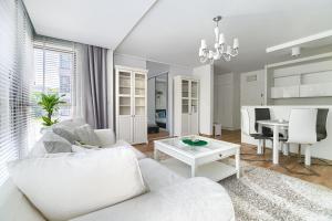 a living room with a white couch and a table at Apartament Eclipse in Szczecin