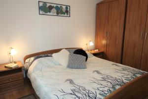 a bedroom with a bed with two lamps and a cabinet at Nikas1 Rabac in Rabac