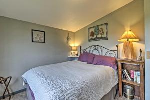 1 dormitorio con 1 cama con almohadas moradas y lámpara en Cozy Duck Lake Cabin Near Glacier Natl Park!, en Saint Mary