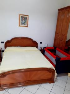 um quarto com uma cama com uma cabeceira de madeira em Casa Cesa em Selargius