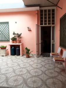 un patio con una pared rosa, sillas y plantas en Casa Cesa, en Selargius