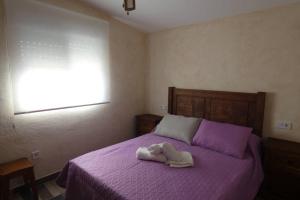 a bedroom with a purple bed with a robe on it at CASA RURAL LA BLANQUITA in Bullas