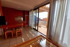 une cuisine avec une table et une vue sur un balcon dans l'établissement Amplio apartamento en la playa del Esquinzo, à Playa Jandía