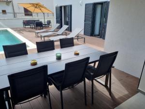 una mesa de comedor con sillas y una piscina en Villa Lana en Valbandon