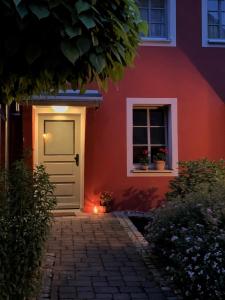 a red house with a white door and a window at Little Vintage in Frankenberg