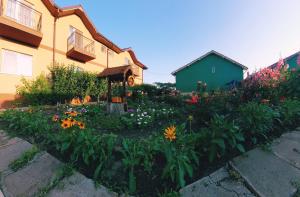 a garden in front of a house with flowers at Casa cu flori in Tuzla