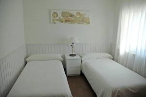 three beds in a room with white walls and curtains at Villa with pool, 200m from beach in Cala Blanca +15 photos