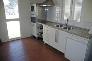 a kitchen with a sink and a stove top oven at Villa with pool, 200m from beach in Cala Blanca