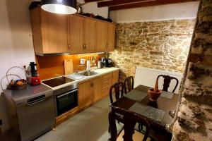 a kitchen with a table and a stone wall at Traditional Stone House in Kissos Pelion in Kissos