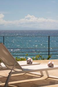 a chair and a table on a balcony with the ocean at Aria By LD Hotel Boutique in Pampatar
