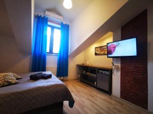 Schlafzimmer mit einem Bett und einem Flachbild-TV in der Unterkunft Station Apartments Katowa 11 in Krakau