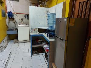 a small kitchen with a refrigerator and a sink at Hotel Posada Tayazal in Flores