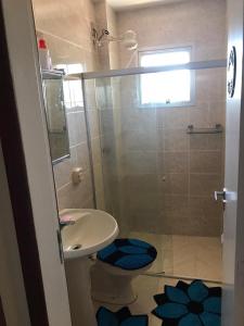 y baño con aseo, lavabo y ducha. en Apartamento a Beira Mar em Setiba Guarapari, en Guarapari