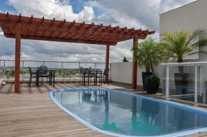 a patio with a swimming pool and a pergola at M Tower Hotel in Pelotas