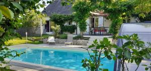 a house with a swimming pool in front of a house at Au Coeur du Bien-Etre, gîte avec piscine chauffée et couverte, SPA, sauna, massages in Monteaux