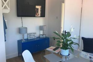 a living room with a blue cabinet and a potted plant at Stylish holiday let in central Broadstairs in Broadstairs