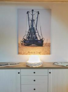 a picture of a ship on top of a dresser at Ferienwohnung Prange Cuxhaven in Cuxhaven