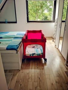 ein Schlafzimmer mit einem Bett mit roter Seite neben einem Fenster in der Unterkunft Ferienwohnung Prange Cuxhaven in Cuxhaven