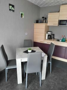 a dining room with a table and chairs in a kitchen at Zettler`s Ferienwohnung in Aichstetten +3 photos
