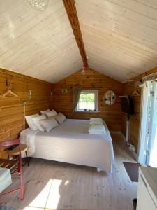 um quarto com uma cama num chalé de madeira em Södra Kärr 4 em Gränna