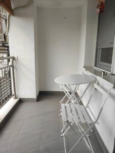 einen weißen Tisch und zwei weiße Stühle in einem Zimmer in der Unterkunft Feels like home 3 in Skopje