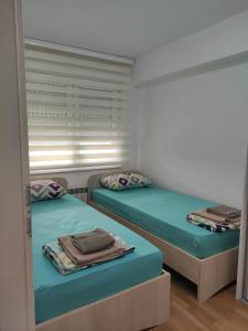 two twin beds in a room with a window at Feels like home 3 in Skopje +6 photos