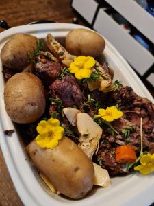 a plate of food with potatoes and flowers on it at Бутик-Отель DREAM VILLAGE Oksino in Oksino