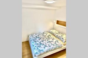 a bedroom with a bed with blue flowers at STUDIO BELA in Radovljica