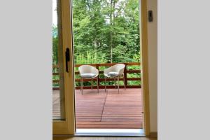 an open door leading to a deck with chairs at STUDIO BELA in Radovljica