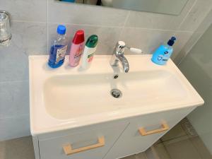 un lavandino in bagno con spazzolini da denti e prodotti per la pulizia di Central Old Town Studio a Bucarest Altre 14 foto