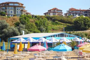 a group of umbrellas and chairs on a beach at Atlantis Atmosphere Apartment in Burgas City