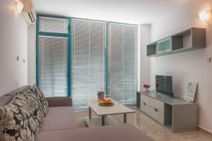 uma sala de estar com um sofá e uma mesa em Top-located Beach Apartment with Balcony em Sunny Beach