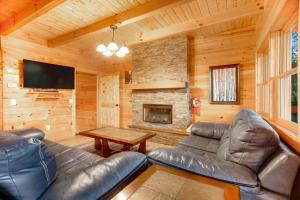 a living room with leather furniture and a fireplace at Mountainside Escape in Gatlinburg