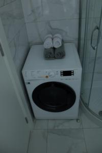 a washing machine in a bathroom with towels on it at Apartman Alina Confort in Banja Luka