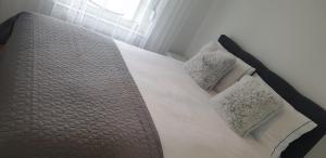 a bed with white sheets and pillows in a bedroom at Apartman Alina Comfort in Banja Luka