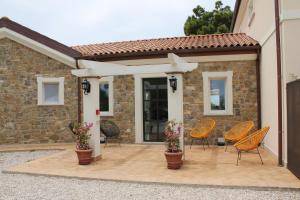 a patio with chairs and flowers in front of a house at Tenuta Bellelli in Castellabate