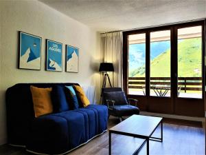 a living room with a blue couch and a table at Appartement à la montagne avec vue Imprenable in Gouaux-de-Larboust