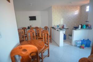a dining room with a table and chairs and a kitchen at Pousada Central in Barreirinhas