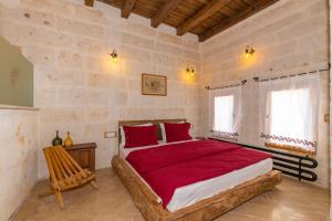 a bedroom with a large bed with red sheets at terracota hotel in Avanos +97 photos