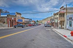 an empty street in a small town with cars parked at Charming Pioche Apartment on Main St Near Hiking! in Pioche