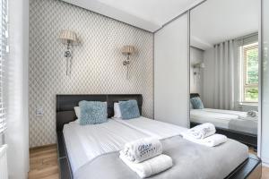 a bedroom with a bed and a dresser at Margi Eclipse Apartament in Szczecin