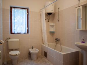 een badkamer met een toilet, een bad en een wastafel bij Petrcane house in Petrcane