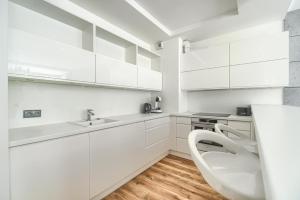 a bathroom with a sink, toilet, and cabinets at Margi Eclipse Apartament in Szczecin