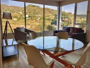 a living room with a glass table and chairs at LA CHOZA VILLA VACACIONAL in Teror