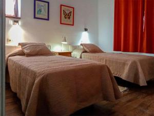 two beds in a room with a red curtain at Villa for 4 with a private Pool & Garden in Bédar