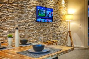 a wooden table with plates and a tv on a stone wall at Cannes Holiday suite à 2 pas du festival in Cannes