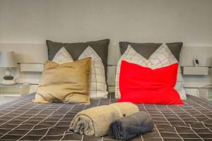 a bed with red and white pillows on it at Cannes Holiday suite à 2 pas du festival in Cannes