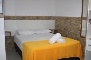 uma cama com duas toalhas numa mesa amarela em Nosso Cantinho Canasvieiras em Florianópolis