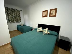 1 dormitorio con 1 cama con sábanas y almohadas azules en Hostal Mellizo, en Lebrija