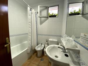 a white bathroom with a sink and a toilet at Hostal Mellizo in Lebrija